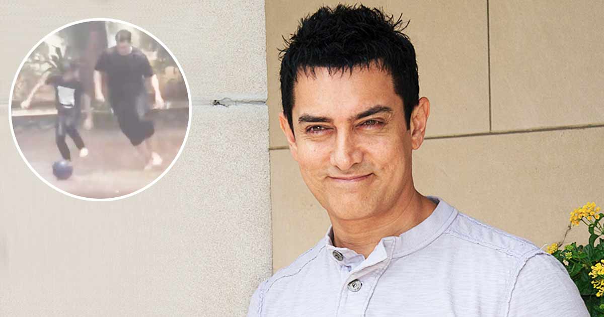 Kicker: Aamir Khan enjoys playing football with son Azad in the rain